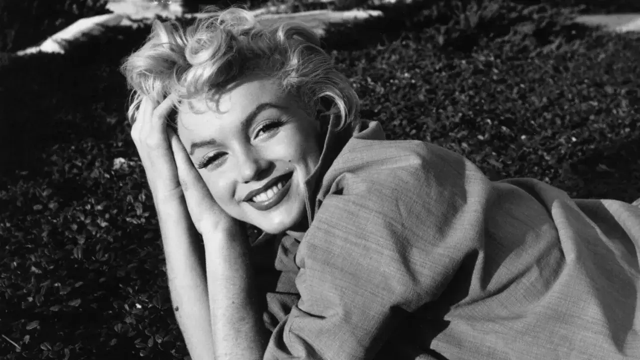Marilyn Monroe ler mot kameran, med armarna vilande under huvudet. En glimt av mitt liv som Marilyn.