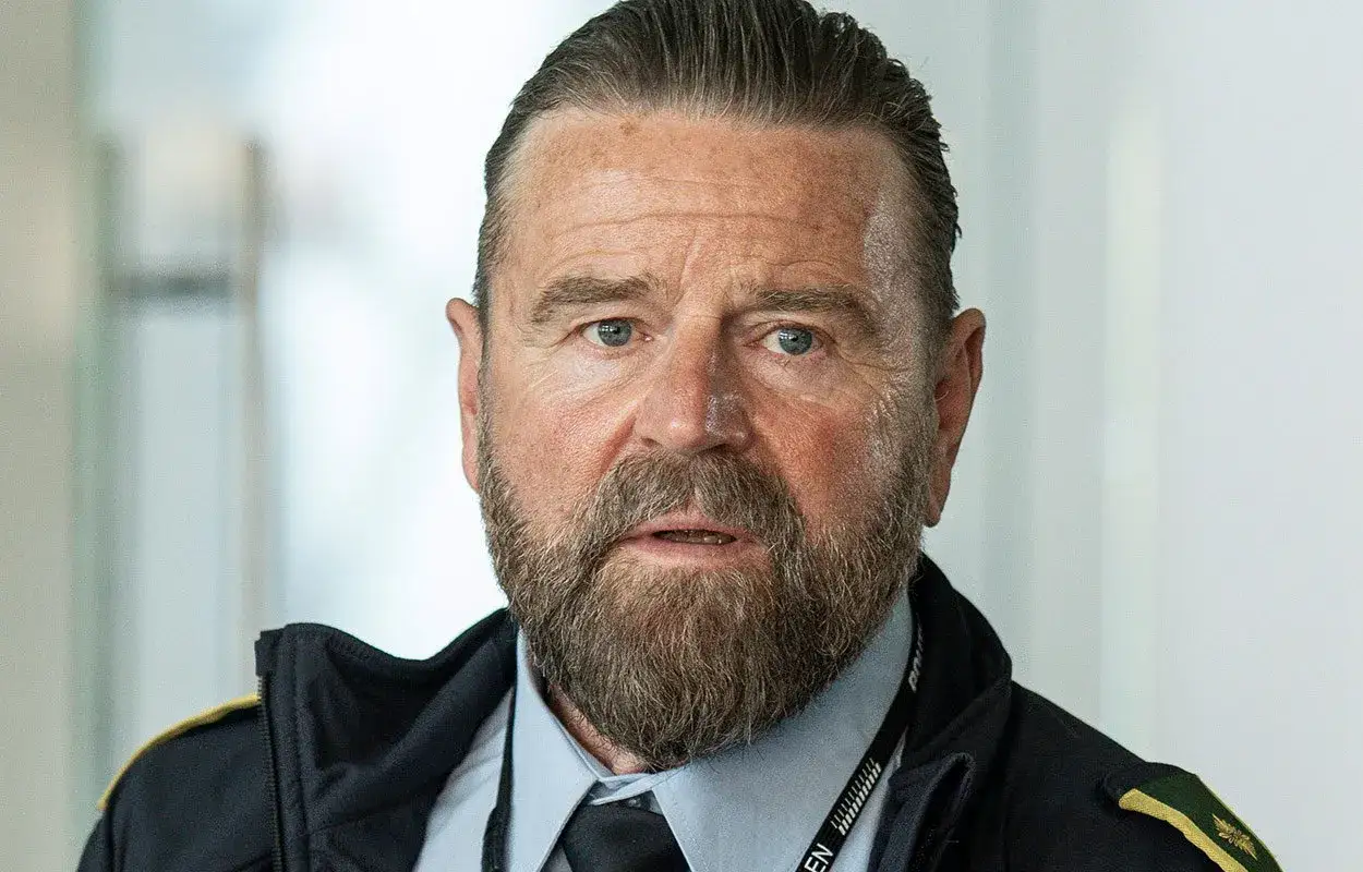 En polis i en svt kriminalserie, med gråsprängt hår, skägg och blå ögon.