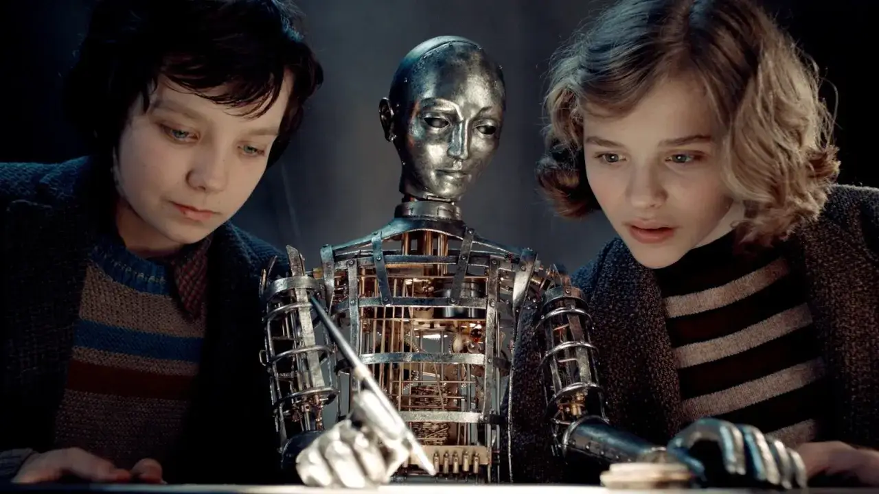 Hugo och Isabelle tittar fascinerat på automaten som skriver. Rollistan i Hugo Cabret väcks till liv.