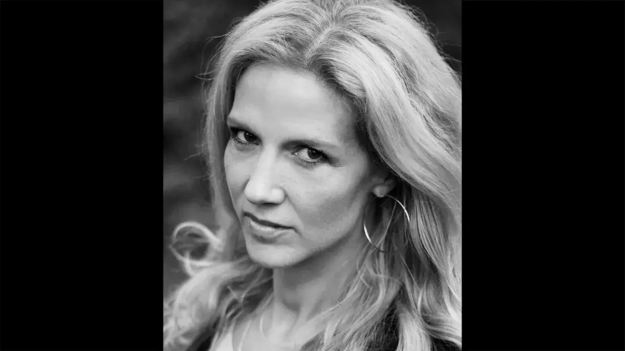 Porträtt av Annika Marklund med blont hår och stora ringörhängen.