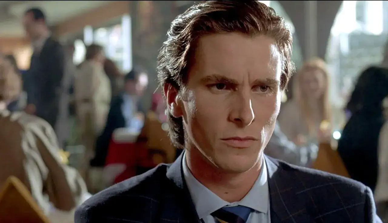 Christian Bale i en m&ouml;rk kostym, med en intensiv blick. En scen fr&aring;n en av hans filmer, kanske American Psycho.