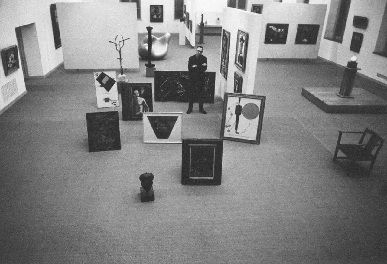 Man i konsthallen, omgiven av konstverk. Kanske en lycklig människa i detta lucky people center.