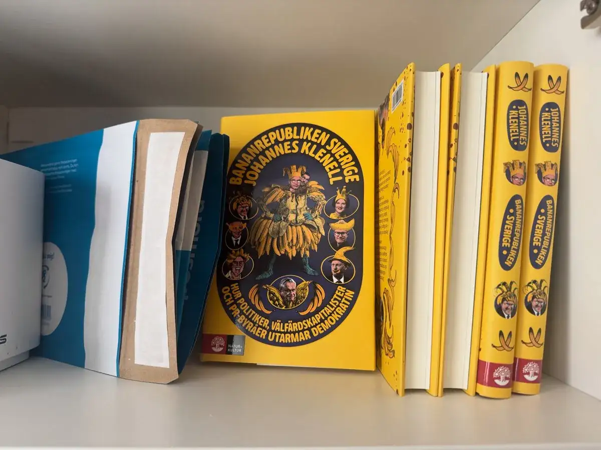 Böcker av Johannes Klenell om Bananrepubliken Sverige. En gul bok med porträtt och tre likadana böcker i ryggen.