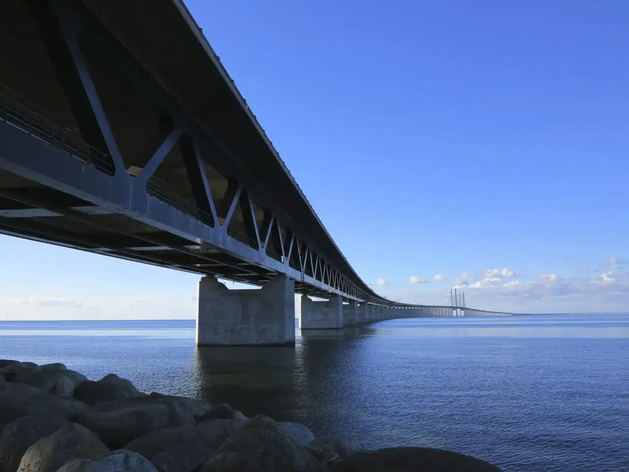 Öresundsbron, en imponerande bron serie, sträcker sig över det blå havet under en klarblå himmel.