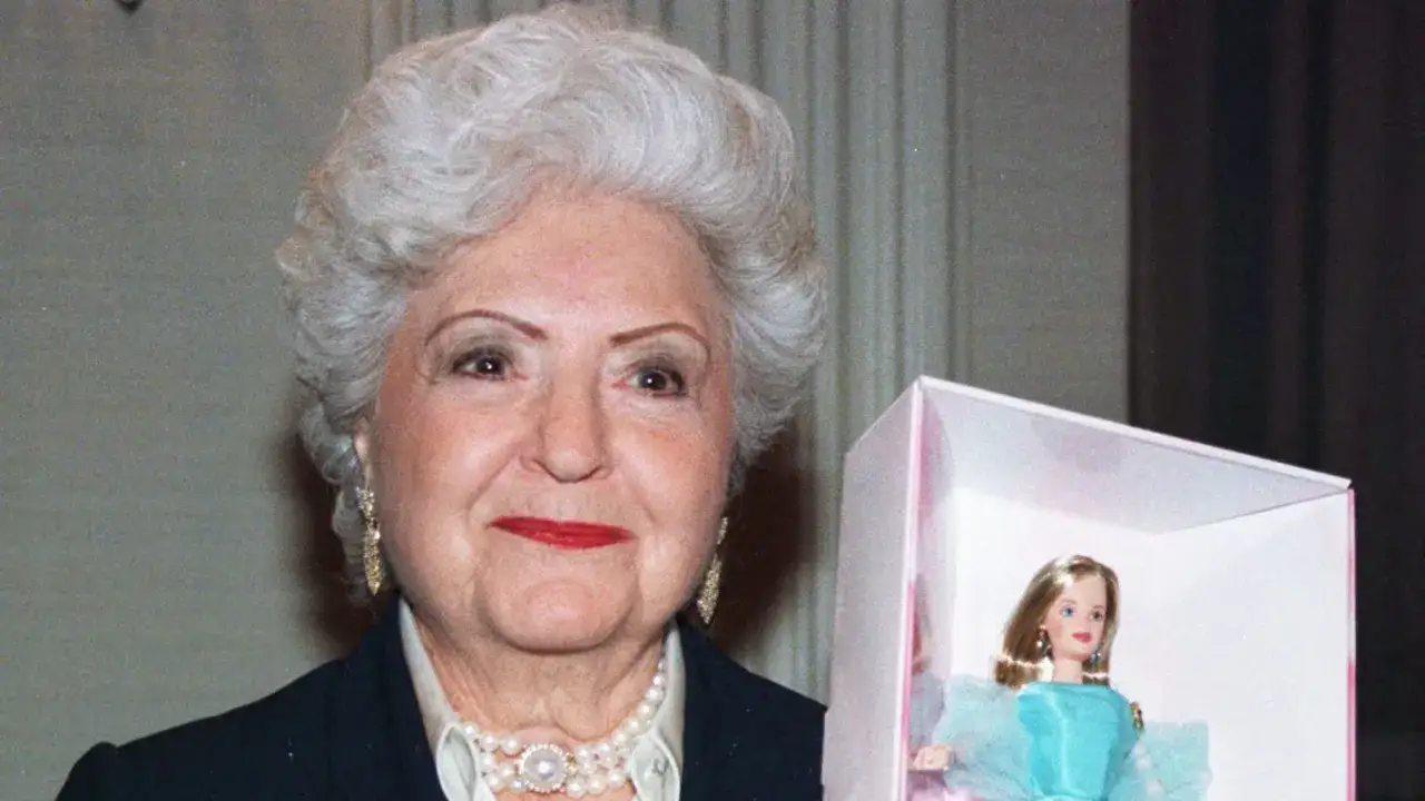 Ruth Handler, skaparen av Barbie, håller stolt upp en av sina ikoniska dockor.