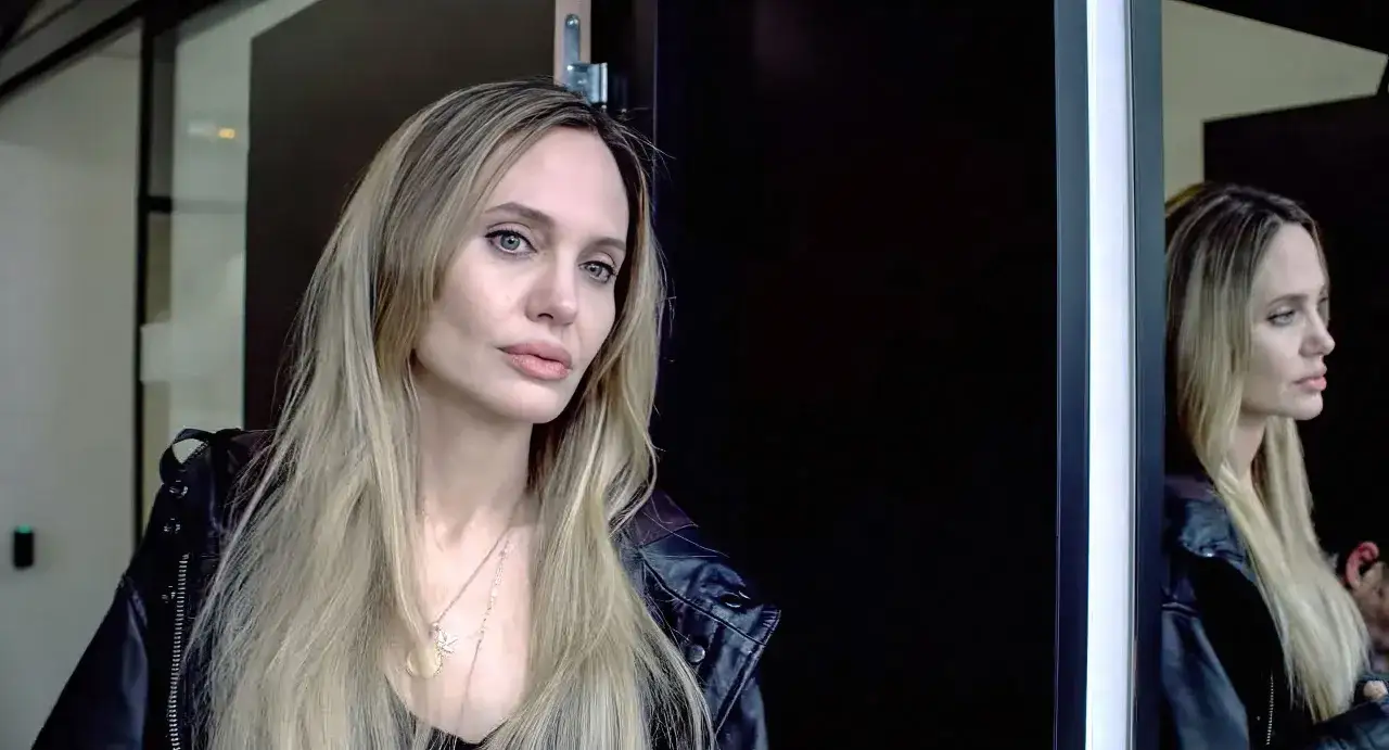 Angelina Jolie, känd från många filmer, bär en svart läderjacka och tittar mot kameran.