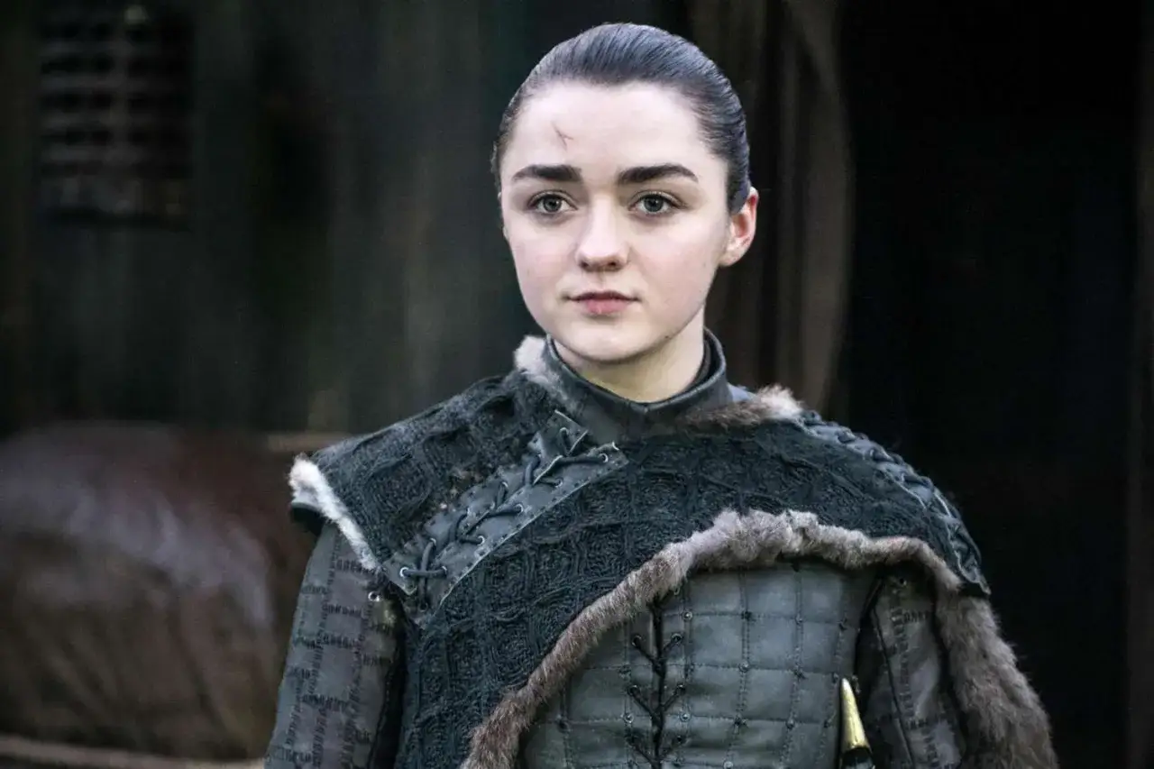 Maisie Williams som Arya Stark, med ett &auml;rr i pannan, b&auml;r en m&ouml;rk, p&auml;lsfodrad rustning.